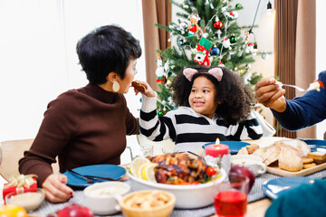 Happy family are having dinner at home. Celebration holiday and togetherness near Christmas tree. African American family. Merry Christmas.