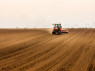 Tractor at agricultural farm field cultivating land