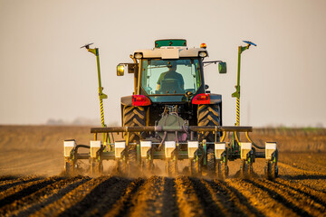 Tractor drilling seeding crops at farm. Agricultural activity.