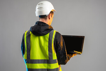 builder laptop. Man in reflective vest with his back to camera. Builder laptop with black screen....