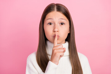 Fototapeta premium Portrait of attractive mysterious brown-haired girl showing shh sign isolated over pink pastel color background