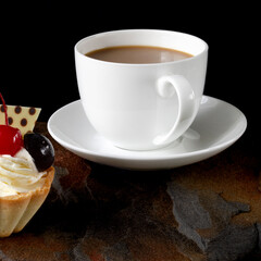 cup of coffee and delicious cake on black background