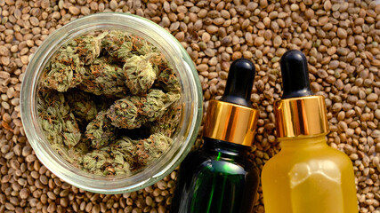 Marijuana cosmetic products, CBD oil. Medicinal hemp stuff on cannabis seeds background. Natural herbal care, medical usage, hemp therapy.