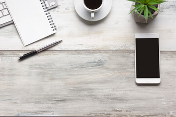 White desk office with laptop, smartphone and other work supplies with cup of coffee. Top view with copy space for input the text. Designer workspace on desk table essential elements on flat lay