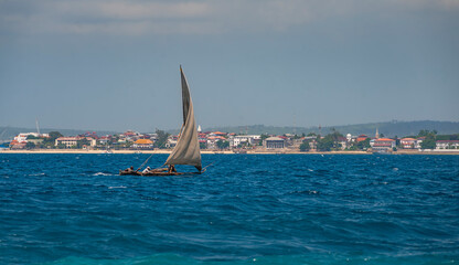 Afrikan fishing sailboat Ngalawa  goes on the deep blue waves near Mnemba island, Tanzania