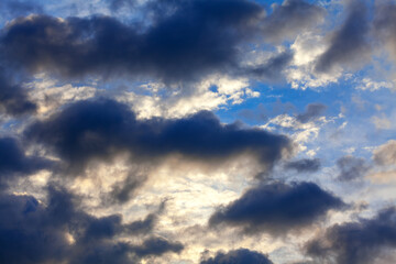 Naklejka na ściany i meble Sunbeams in dark clouds . Evening dramatic sky 