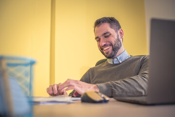 Fototapeta premium businessman smiling and typing on notebook