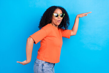Fototapeta na wymiar Profile side photo of young african cheerful woman happy positive smile dance party isolated over blue color background