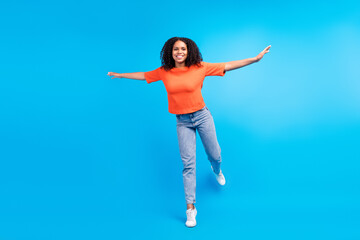 Fototapeta na wymiar Full size photo of young african excited woman happy positive smile hands plane fly isolated over blue color background
