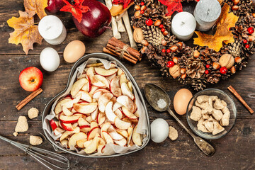 Apple charlotte is ready to bake. Kitchen utensil, set of ingredients, seasonal decor