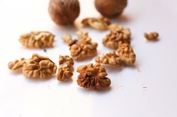 Whole and cracked walnuts on white background, selective focus