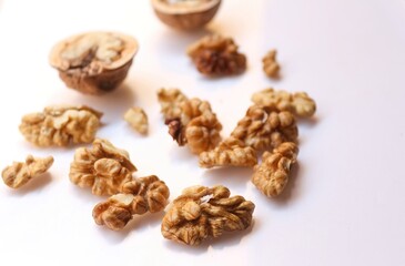 Fototapeta na wymiar Whole and cracked walnuts on white background, selective focus