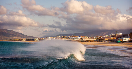 Panoramic view of a large ocean wave with swell breaking on the beach at sunrise with easterly wind, Los Lances beach, Tarifa, Cadiz, Andalusia, Spain © inigolaitxu