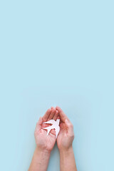 International and national bird day. Hands of mother and child holding white bird on light blue background. World peace day concept. Banner or congratulation card