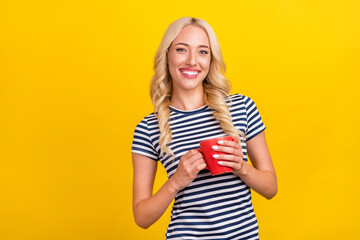 Portrait of attractive cheerful girl drinking latte free time good morning isolated over shine yellow color background