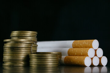 Cigarettes.Tobacco Cigarettes and money coins.Cigarettes and TAX concept. Smoking is a waste of...
