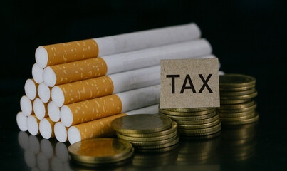 Cigarettes and TAX word on black background.Cigarettes and TAX concept. Smoking is a waste of money.Cost of smoking, Cigarette price concept.