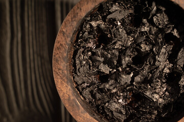 Hookah bowl with burnt tobacco and charcoal for smoking on a dark background. Place for your text.