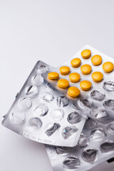 Empty plastic package of pills and blister with yellow pills. Concept of healthcare and medicine.