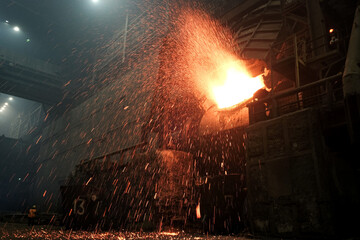 Sparks fly from a smelting furnace in a factory. Close-up