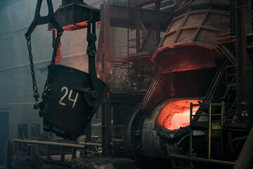 Metallurgical plant. The ladle directs the hot iron into the smelting furnace. Close-up
