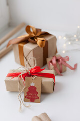 christmas gift boxes with ribbons on white table - wrapping christmas presents