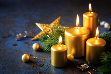 Christmas celebration concept with lit golden candles with festive decorations against adrk blue...