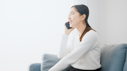 笑顔で電話をする若い女性