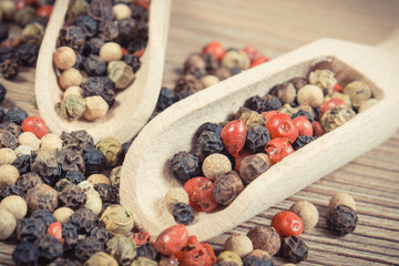 Colored pepper on wooden board as cooking spice