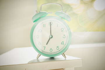 Circadian rhythms concept - alarm clock set on 7 am with sun rays