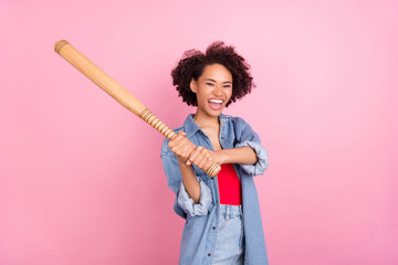 Photo of playful crazy hipster lady hold baseball bat hit air wear denim jacket isolated pink color...