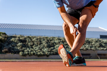 close-up view of unrecognizable man stretching calf-muscle before start running, copy space,