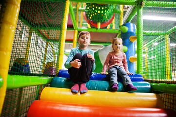 Fototapeta na wymiar Brother with sister playing in indoor play center.