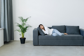 Beautiful young woman is sleeping and seeing sweet dreams at couch