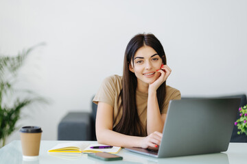 Beauitul young woman working using computer laptop concentrated and smiling at home office