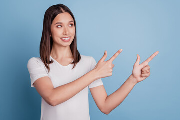Portrait of interested adorable lady indicate fingers side look empty space sale promo on blue background