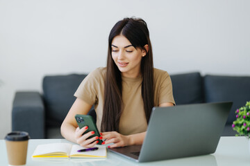 Woman using her cellphone, working from home office