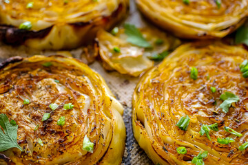 Roasted cabbage steak, baked cabbage in the oven with spices close-up. Vegan cuisine, white cabbage recipe. Homemade authentic dish, baked vegetables background. Healthy food concept, vegetable side 