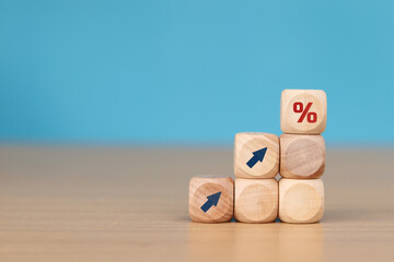 wooden cube block with arrow icon pointing towards percentage symbol icon, Finance and Mortgage Concepts interest rate
