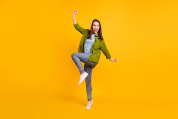 Fototapeta na wymiar Photo of adorable pretty young woman dressed green shirt dancing smiling isolated yellow color background