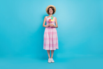 Full size photo of pretty millennial lady hold toy wear hat long sarafan isolated on blue background