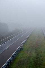 A car drives through fog on a freeway with little traffic. Highway with no traffic on a foggy day. Galicia. Spain