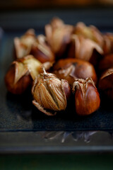 Top view of chestnuts on a dark surface. Food. Fried delicious fresh chestnuts. Shallow depth of field. Dark tonal image. Food.