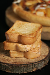 the close up view of a pile of toasted white bread on the wooden paddle. a shot of the western breakfast suitable for advertisement or presentation.