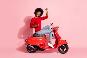 Fototapeta na wymiar Full length profile side photo afro american lady celebrate win sit motorbike isolated on pastel pink color background