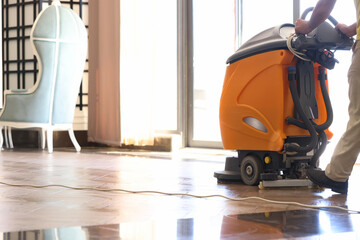 Cleaner washing floor in hotel using special machine closeup