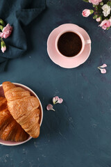 Black coffee with cinnamon and croissant