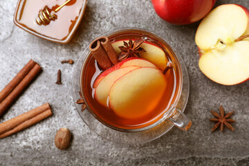 Aromatic hot mulled cider on grey table, flat lay
