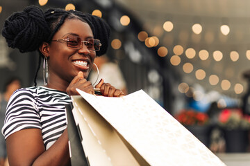 Attractive happy African American young woman shopping on Black Friday shopping mall with packages, Shopping concept