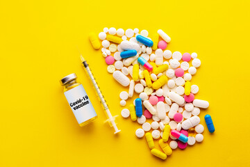 Fototapeta na wymiar Vaccine.Vaccine and syringe on a yellow background. Vaccine with mask and pills.Medicine concept. Corona virus concept. Covid 19 vaccine.Vaccination against covid 19. Pills or vaccination.copywriting
